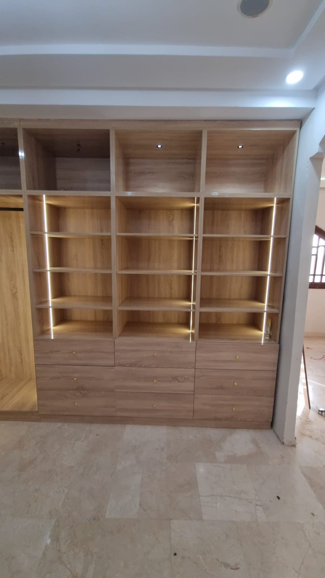 Salón con librería empotrada y paneles de madera